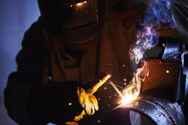 Closeup male in face mask welds with welding