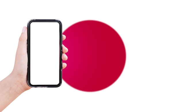 Closeup of male hand holding smartphone with blank on screen on background of blurred flag of Japan