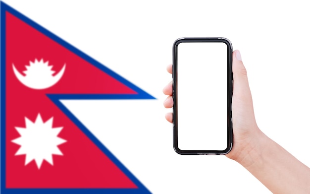 Closeup of male hand holding smartphone with blank on screen on background of blurred flag of Nepal