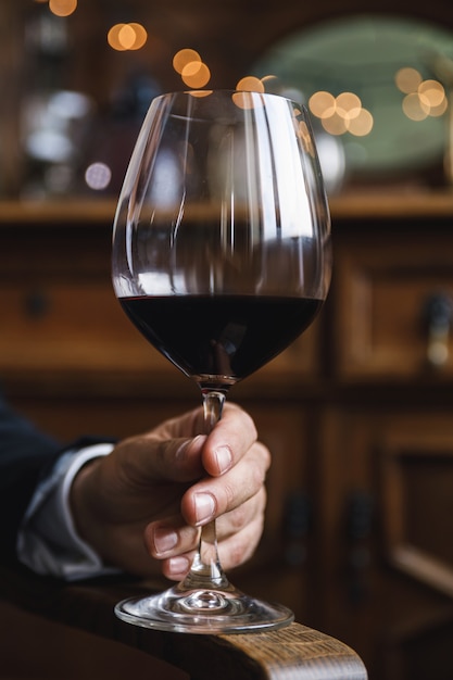 Closeup of male hand with a glass of red wine