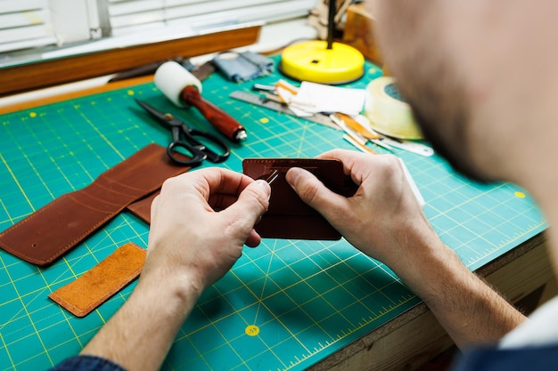 Closeup of male hands working with natural leather Handmade products made of genuine leather