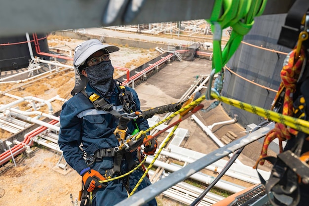 Closeup male worker standing on tank male worker height roof tank knot carabiner rope access safety