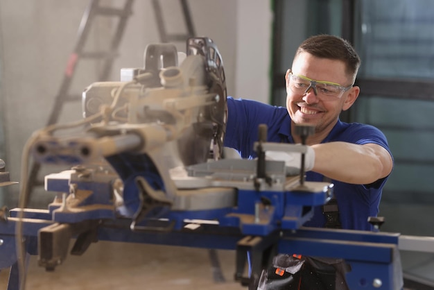 Closeup of man carpenter working in protective glasses using special equipment professional