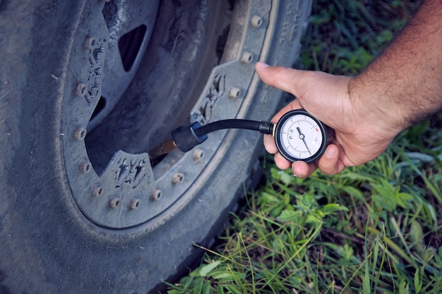 Closeup of a man checking and measuring tire pressure