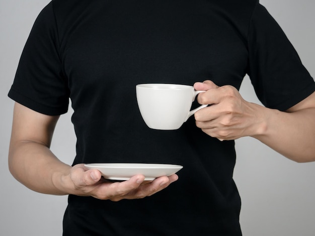 Closeup man hand holding coffee cup studio shot