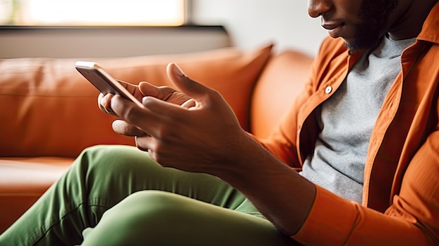 Closeup of a man hands using his cell phone while sitting on a couch checking messages and mail