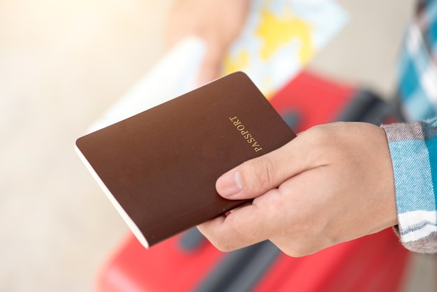 Closeup of man holding passports and boarding pass at airport