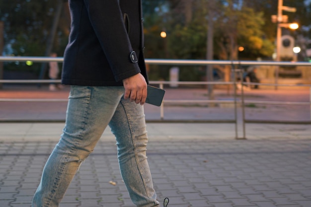 Closeup of a man holding a phone on the street