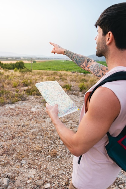 Closeup of a man pointing to the horizon with a map