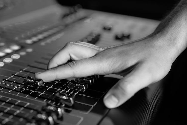 Closeup of a man's hand controlling a professional sound remote control