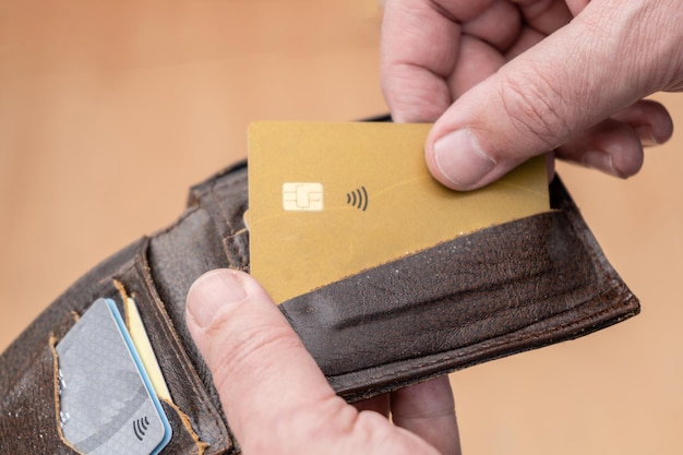 Closeup of a man's hand taking out a credit card from a personal document holder