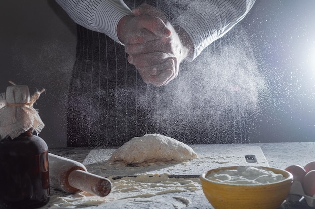 Photo closeup of a man's hands kneading dough to make homemade noodles