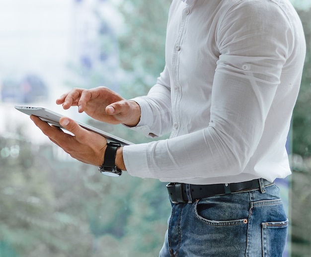 Closeup of man's hands that is using tablet pc indoor