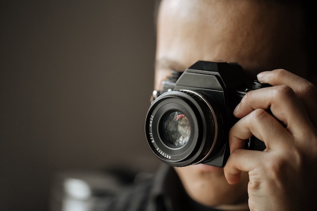 Closeup on man taking a picture on a pentax film camera