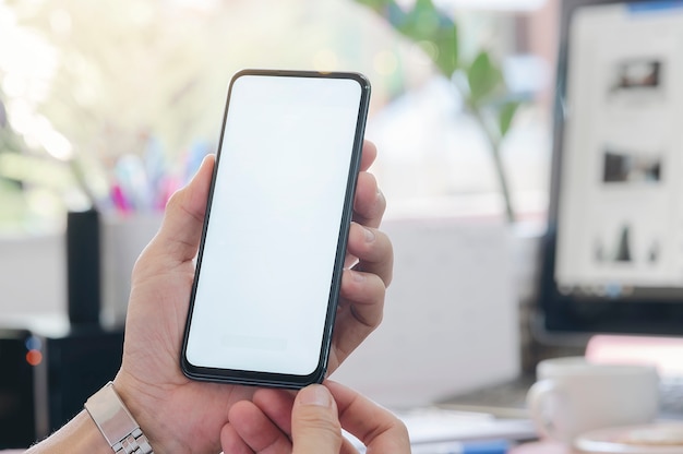 Closeup man using smartphone at  office. Blank screen for graphics display montage.