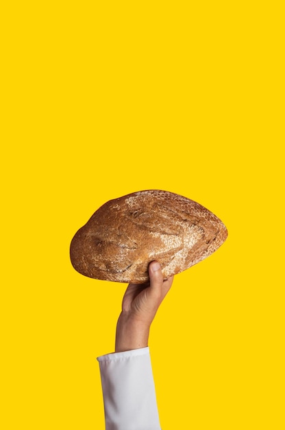 Closeup of a man39s hand with a loaf pan on yellow background