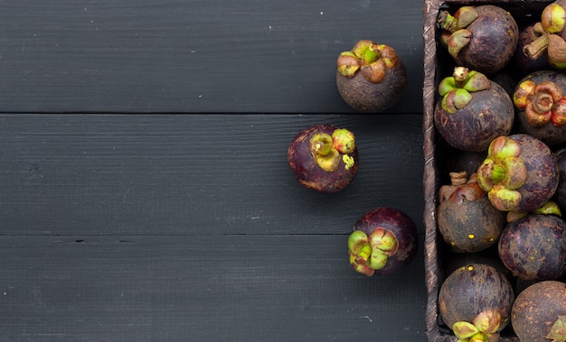 Photo closeup mangosteen fruit on black wood