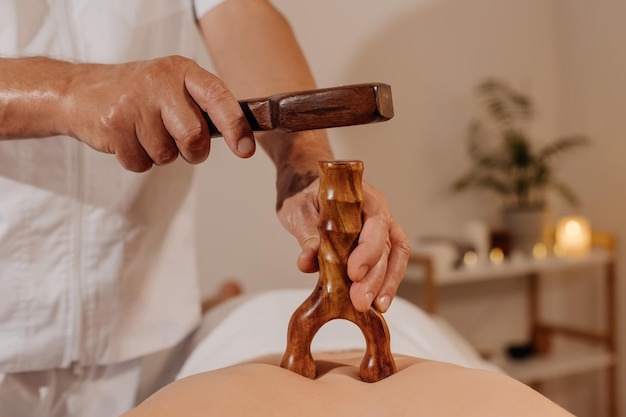 Closeup mans back during traditional thai toksen massage oriental alternative medicine