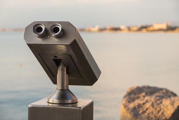 Closeup metal binoculars for public use with views of the beautiful port and sea