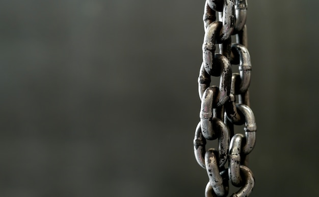 Closeup metal chain on old drick wall 