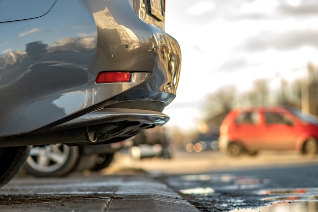 Closeup of a modern cars parked on a side of a city street on a sunny day.