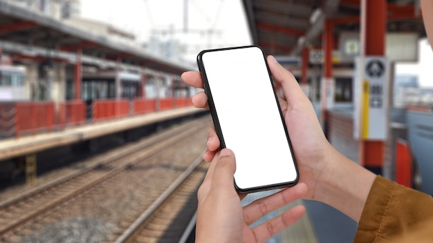 Closeup montage woman's hands holding smartphone on railway translation in Japan.