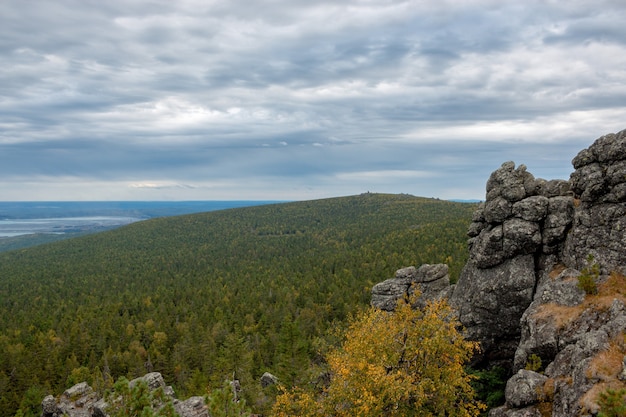 Closeup mountains scenes in national park Kachkanar, Russia, Europe. Cloudy weather, dramatic blue color sky, far away green trees. Colorful summer day