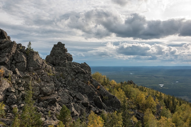 Closeup mountains scenes in national park Kachkanar, Russia, Europe. Cloudy weather, dramatic blue color sky, far away green trees