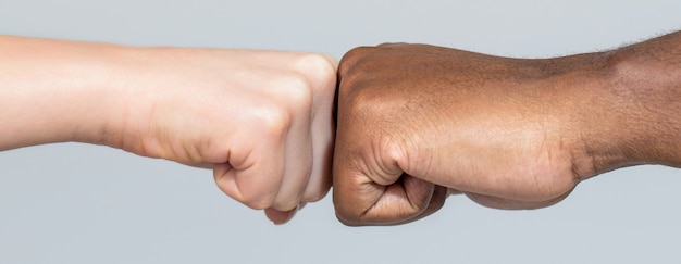 Photo closeup of multicultural friends giving fist bump to each other. black african american race male and woman hands giving a fist bump, multiracial diversity, immigration concept