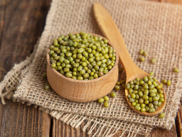 Closeup mung beans Green mung beans in a wooden bowl on an old table