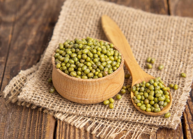 Closeup mung beans Green mung beans in a wooden bowl on an old table