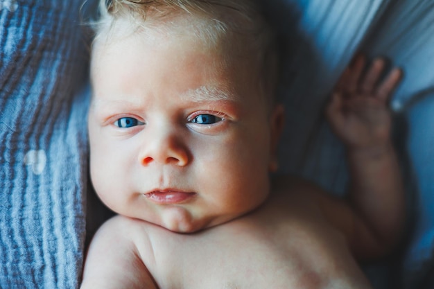 A closeup of a newborn baby's face A newborn is looking at the camera Open eyes of a newborn baby