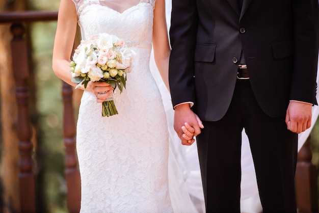 Closeup newly weds are holding each other's hand