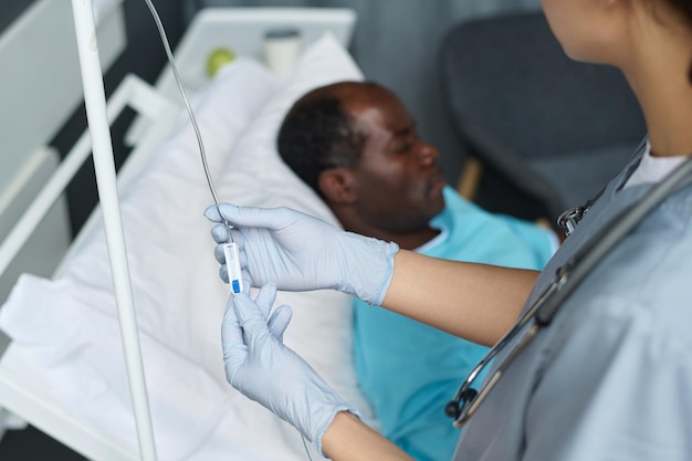 Closeup of nurse making dropper for patient standing in hospital ward