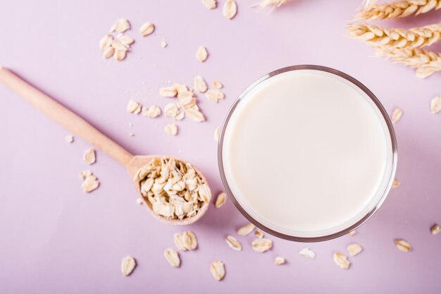 Closeup of oat milk in a glass and oatmeal on the table Alternative to lactose Top view