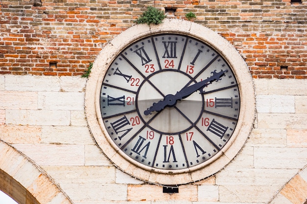 Closeup of old clock of the medieval Porta Nuova, gate to the old town of Verona in Italy