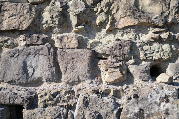 Closeup of old stone wall background dark rock surface nature texture gray backdrop