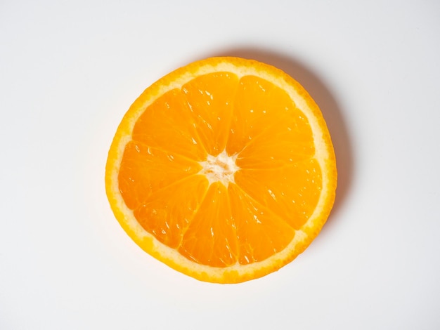 A closeup of an orange cut into slices lies on a white background Delicious beautiful fruit full of vitamins Studio shot top view flat lay