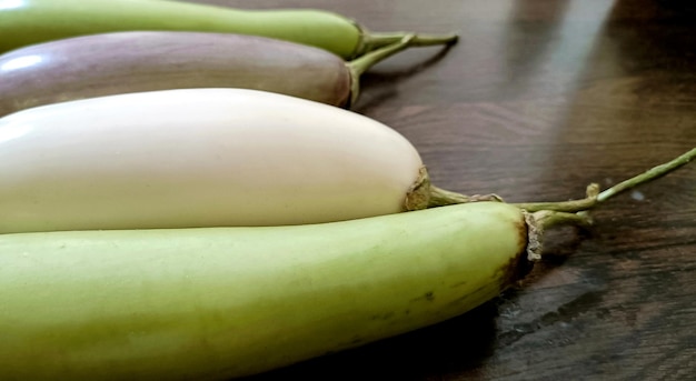 Closeup of organic white and green fresh eggplant or brinjal isolated on wooden background