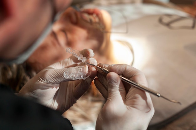 Closeup of an orthodontic specialist holding an invisible aligner in his hand