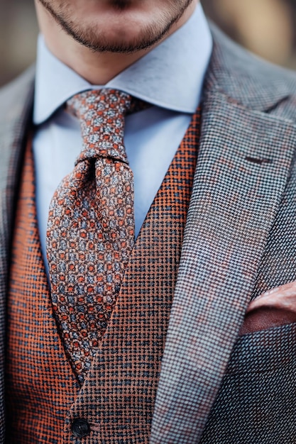 Photo closeup of a patterned tie paired with a contrasting dress shirt and blazer highlighting the fashion ensemble