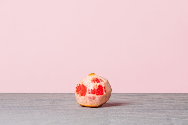 Closeup of a peeled grapefruit on a pink