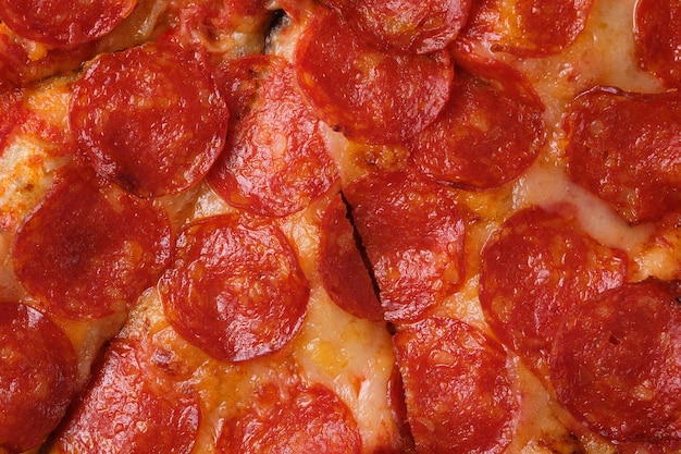 A closeup of a pepperoni pizza. Pizza with spicy sausage, tomato sauce and mozzarella cheese.