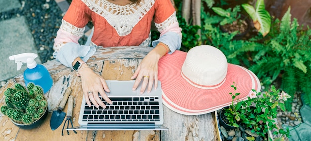 Closeup of person working in garden with laptop