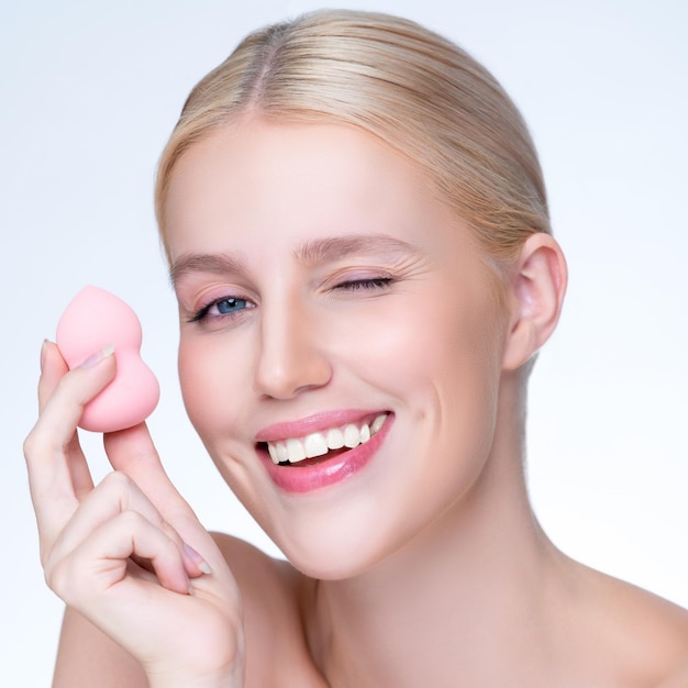 Closeup personable natural makeup woman using powder puff for facial makeup