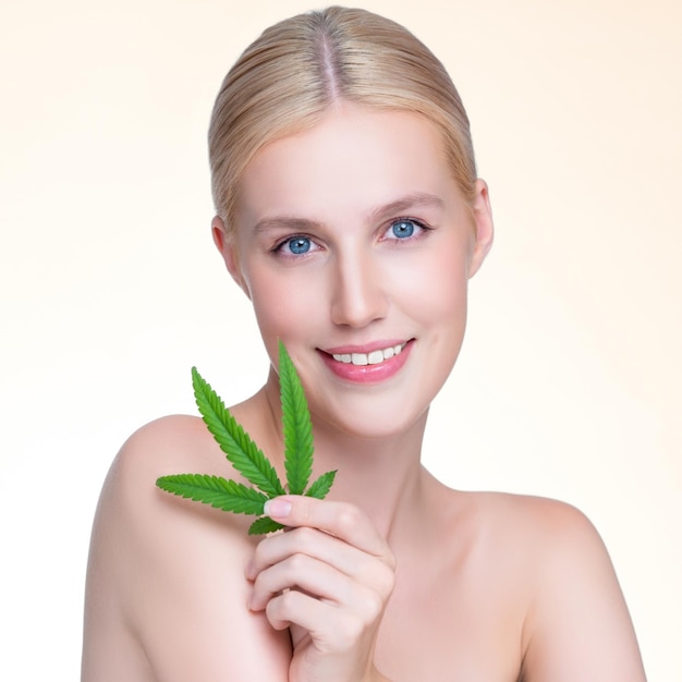 Closeup personable woman hold green leaf as cannabis beauty concept