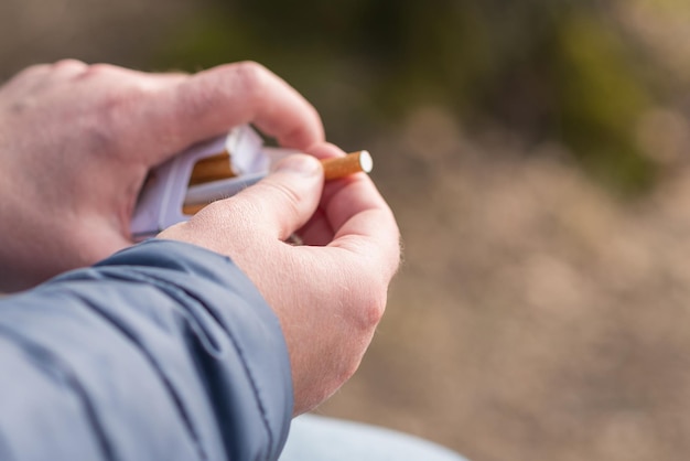 closeup persons hand pick a cigarette from the carton cigarettes pack box