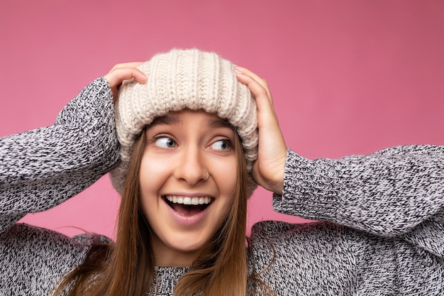 Closeup photo of attractive positive shocked amazed young dark blonde woman isolated over colourful background wall wearing everyday trendy clothes looking to the side showing facial emotions.