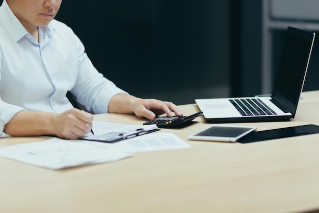 A closeup photo of a businessmans hand working on paperwork an accountant a financier calculates