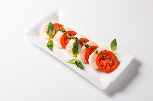 Closeup photo of caprese salad with ripe tomatoes basil buffalo mozzarella cheese Italian and Me